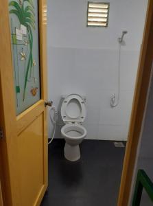 a bathroom with a toilet with the lid up at Fort Sea View Hotel in Matara