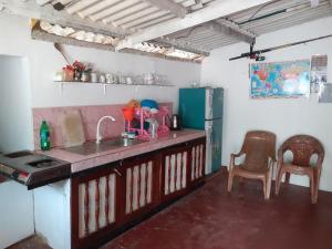 a kitchen with a sink and a refrigerator and chairs at Fort Sea View Hotel in Matara