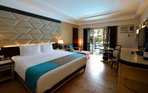 a hotel room with a large bed and a desk at Henann Regency Resort and Spa in Boracay