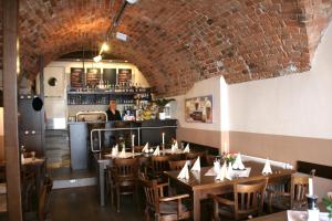 a restaurant with wooden tables and a brick wall at Hotel Zittauer Hof in Zittau