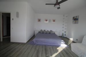 a bedroom with a bed and a ceiling fan at Casa do Milho in Carvoeiro