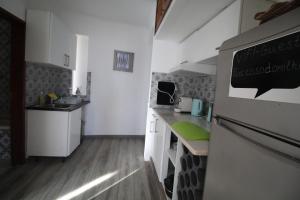 a small kitchen with white cabinets and a sink at Casa do Milho in Carvoeiro