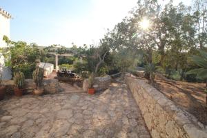 a garden with a stone wall and trees and plants at Casa do Milho in Carvoeiro