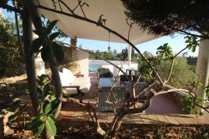 a porch with a swing and a chair on a patio at Casa do Milho in Carvoeiro
