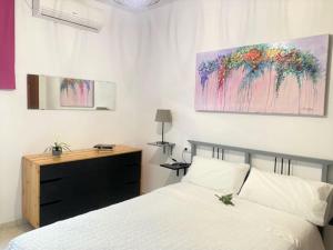 a bedroom with a bed and a painting on the wall at Apartamento entero a 10 minutos en coche de Sevilla Centro in Camas