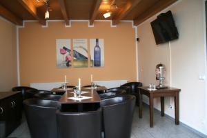 un restaurante con sillas negras, una mesa y una botella de vino en Hotel Zittauer Hof, en Zittau