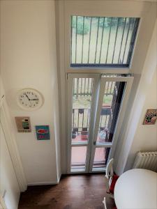 une chambre avec une horloge et une porte avec une fenêtre dans l'établissement White flat Puglie, à Milan