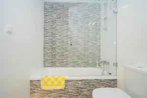 a bathroom with a shower and a tub with a yellow stool at Stachera in San Pedro del Pinatar +57 photos
