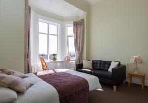 sypialnia z łóżkiem, kanapą i oknem w obiekcie Glencourt Apartments w Dublinie