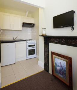 a kitchen with white appliances and a tv on the wall at Glencourt Apartments in Dublin