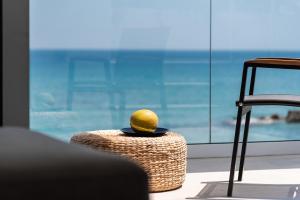 a lemon sitting on top of a stool in front of a window at Zen Luxury Villas & Suites, By ThinkVilla in Hersonissos