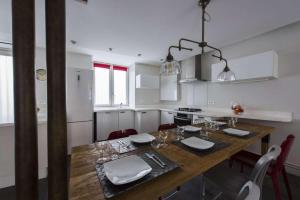 a kitchen with a wooden table with chairs and a dining room at Bahia in Paris