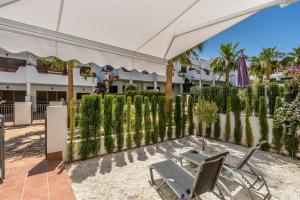 eine Terrasse mit einem Zaun, einem Tisch und Stühlen in der Unterkunft Rosa in San Juan de los Terreros