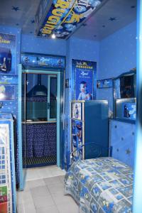 een blauwe kamer met een bed en een man in de deuropening bij Appartamento Catania Center in Catania
