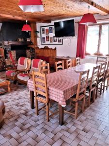 a dining room with a table and chairs and a television at grand gite in Cier-de-Luchon