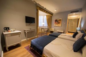 a hotel room with two beds and a television at Classic Hotel in Tirana