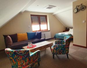 salon z kanapą, krzesłami i łóżkiem w obiekcie Pod Herbami w mieście Frysztak