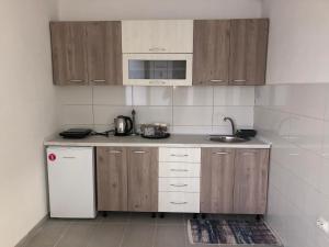 a kitchen with wooden cabinets and a sink and a refrigerator at Astoria Luxe in Kumanovo