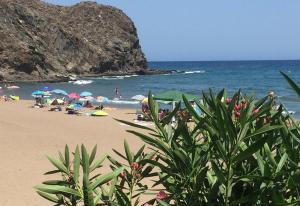 - une plage avec des parasols et des personnes sur la plage dans l'établissement Beach House in Puntas de Calnegre, à Mazarrón