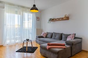 een woonkamer met een bank en een tafel bij BRAND NEW - SelfCheckIns 24 - Zagreb - Garage - Loggia - New - Luxury in Zagreb