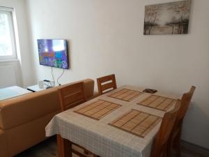 mesa de comedor con sofá y TV en Apartment Azra - Sarajevo, Ilidza, en Sarajevo