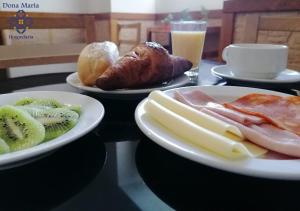 two plates of food on a table with fruit and bread at Hospedaria Dona Maria in Beja