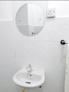 a white bathroom with a mirror and a sink at Neighbourly Nest in Mombasa +14 photos