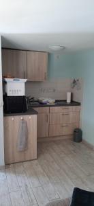 a kitchen with wooden cabinets and a counter top at Bungalow Waldblick in Ganzlin +3 photos