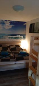 een slaapkamer met een bed en een schilderij van de oceaan bij Bungalow Waldblick in Ganzlin