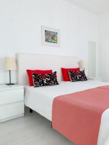 two beds in a bedroom with red and white at Casa Branca in Tavira