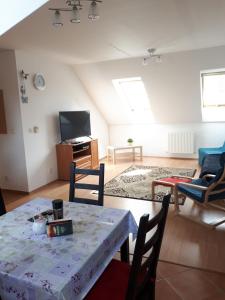 a living room with a table and a tv at apartment in Biely Kostol