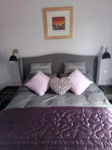 1 dormitorio con 1 cama con almohadas rosas en The POD Unique & Stylish Luxury Accommodation With Hot Tub, en Swanlinbar