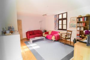 a living room with a red couch and a table at Im Grünen am Stadtrand in Saarbrücken