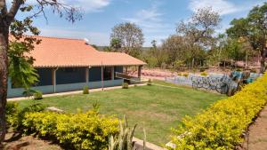 a house with a garden with yellow flowers at Recanto Malop in Três Marias