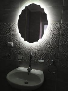 a bathroom with a sink and a mirror at شقةعلى البحرمباشرةسيدي بشرالمربع الذهبي in Alexandria