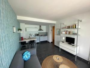 a living room with a couch and a kitchen at Escapade au bord du lac du Bourget in Le Bourget-du-Lac