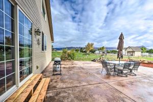 a patio with a table and chairs and an umbrella at The Vineyard Country Farm Home at Grand Valley in Grand Junction