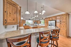 una cocina con armarios de madera y una isla con taburetes. en The Vineyard Country Farm Home at Grand Valley, en Grand Junction