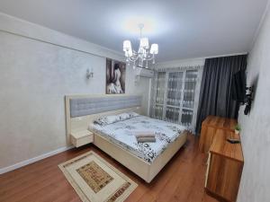 a bedroom with a bed and a chandelier at New Apartments fresh Design in the Centre in Chişinău