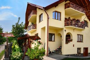 a large yellow building with balconies and windows at Sub Creasta Cocosului in Breb