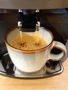 a cup of coffee is being being brewed at CityApartment - 53 m², 2 Zimmer, zentral, Netflix, Küche, Waschmaschine in Cottbus