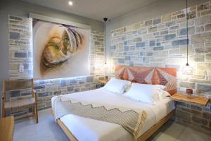 une chambre avec un lit et un mur en pierre dans l'établissement Phaestias Terra Villas, à Kalamaki 64 autres photos