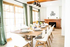 a dining room with wooden tables and white chairs at Family villa in Alicante, saltwater pool, AC and bbq in Alicante