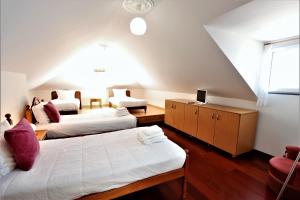 - une chambre mansardée avec 2 lits et un canapé dans l'établissement Casa do Seixal, à Seixal