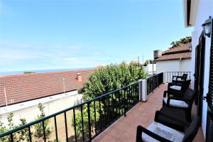 d'un balcon avec des chaises et une vue sur l'océan. dans l'établissement Casa do Seixal, à Seixal