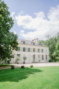an exterior view of a white house with a yard at Domaine et Château de Séréville in La Belliole