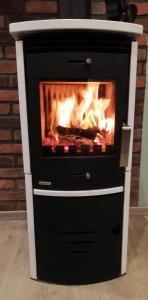 a black and white stove with a fireplace at Drifthof in Glowe