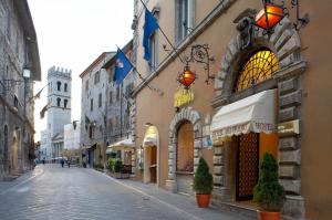 una calle vacía en un viejo pueblo con edificios en Dei Priori Boutique Hotel en Assisi