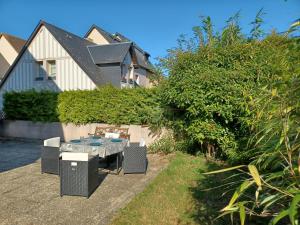 a patio with a table and chairs in front of a house at L'escale honfleuraise in Honfleur