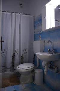 a bathroom with a toilet and a sink at Thalis Rooms in Skoutari